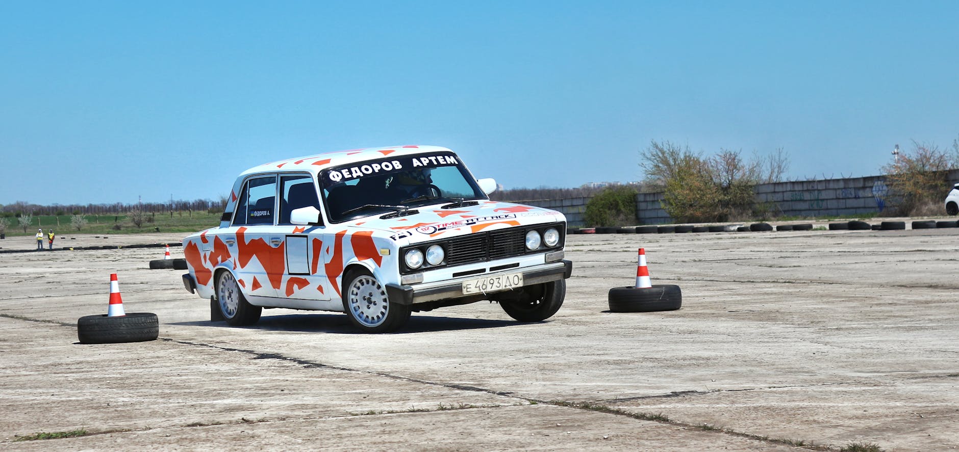 Samochód ozdobiony naklejkami na torze przeszkód z pachołkami