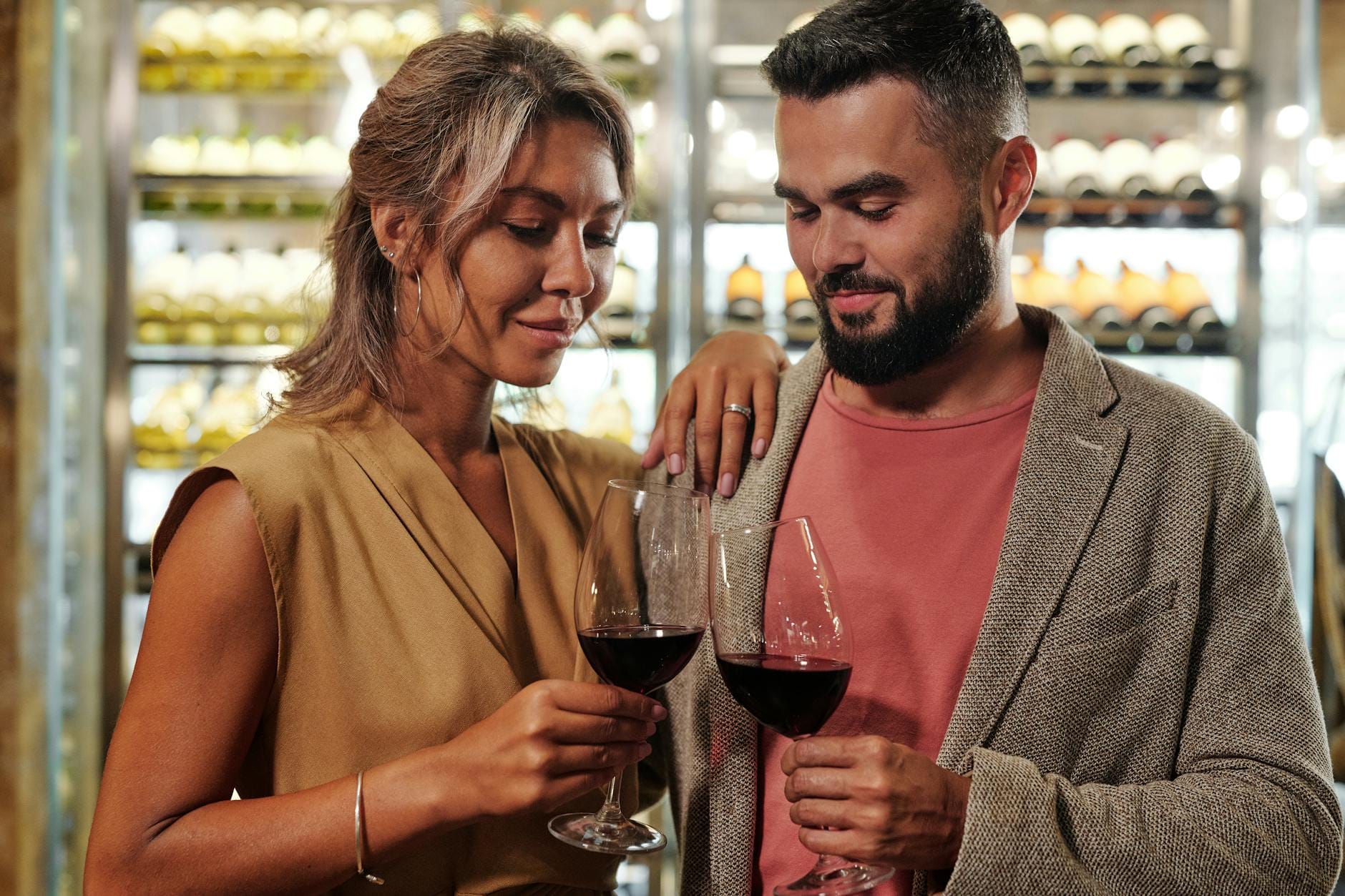 Elegancka para w piwniczce winiarskiej wznosi toast kieliszkami wina