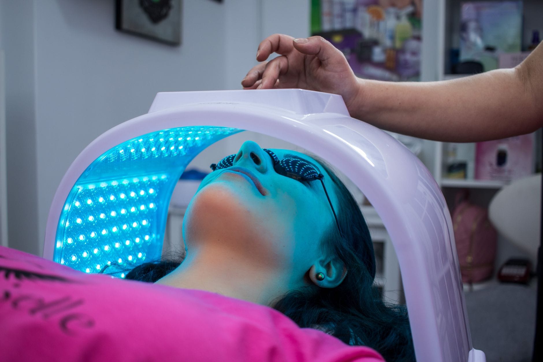 Kobieta podczas zabiegu pod lampą UV w nowoczesnym salonie kosmetycznym
