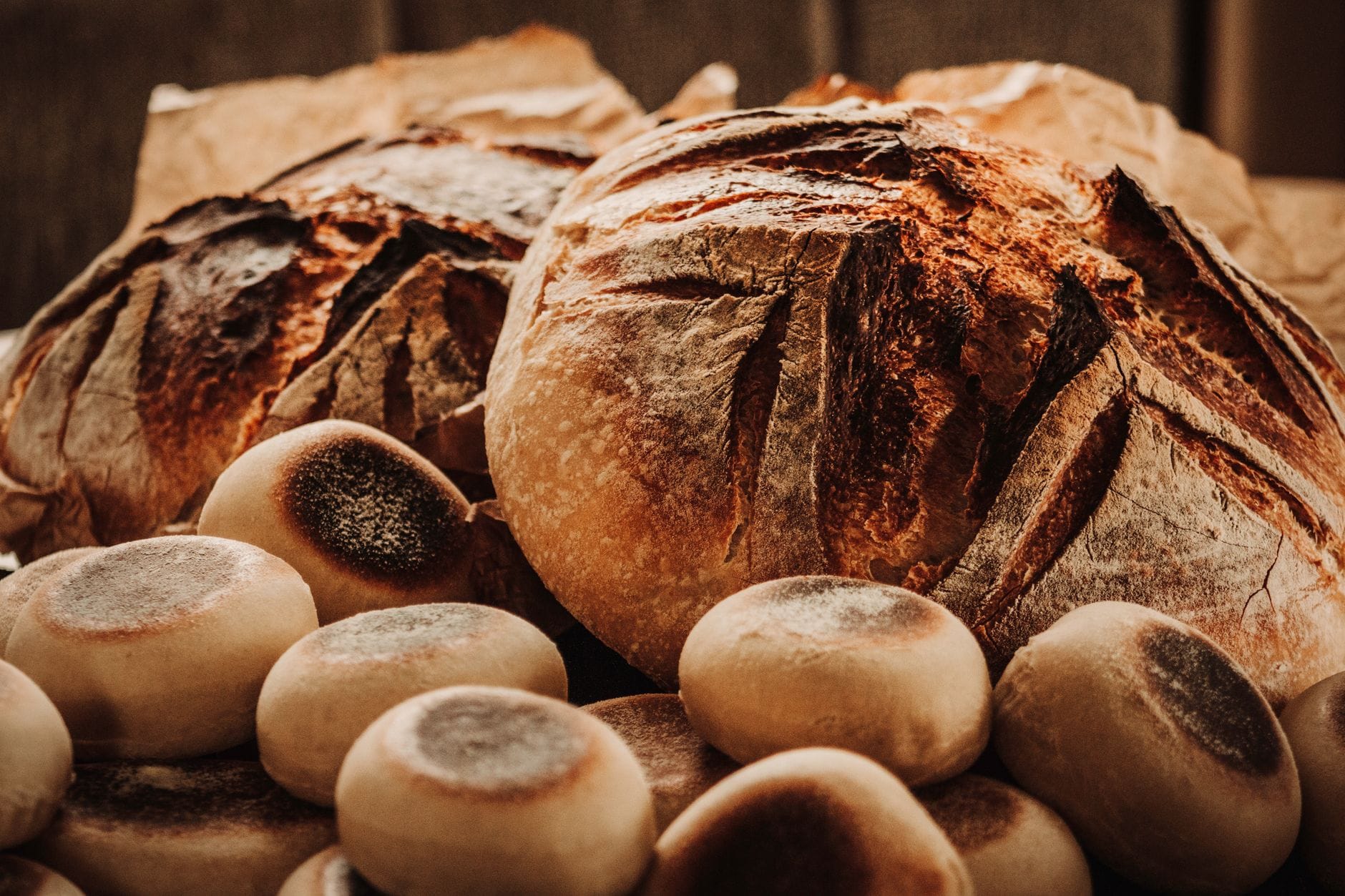 Domowy chleb na zakwasie krok po kroku – prosty przepis dla początkujących Zbliżenie na świeżo upieczone, rustykalne bochenki chleba na zakwasie